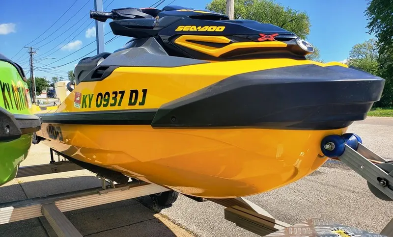 Slide: The Image of 2021 Sea-Doo RXT jet ski in yellow on a trailer. - 2