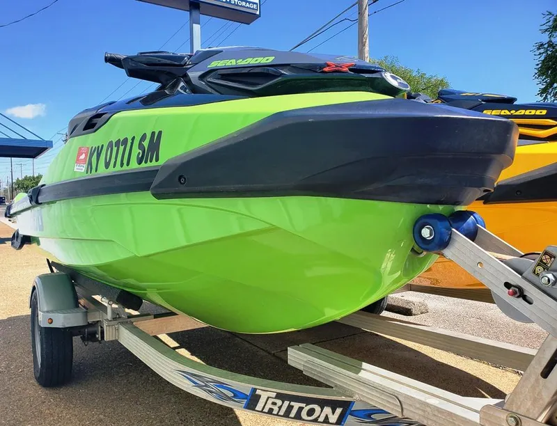 Slide: The Image of 2021 Sea-Doo RXT on Triton trailer, green and black, parked outdoors. - 9