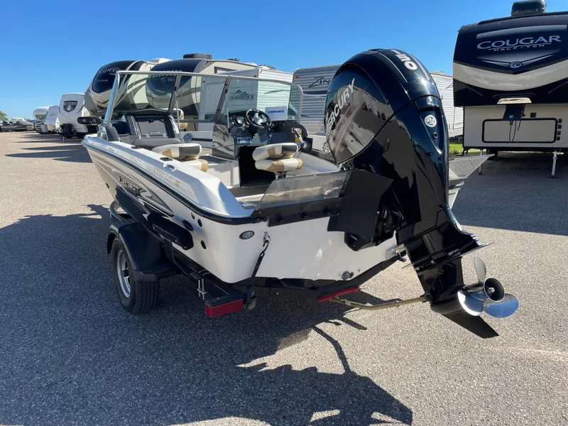 Slide: The Image of 2012 Larson FX 1750 DC boat with outboard motor in a parking lot. - 4