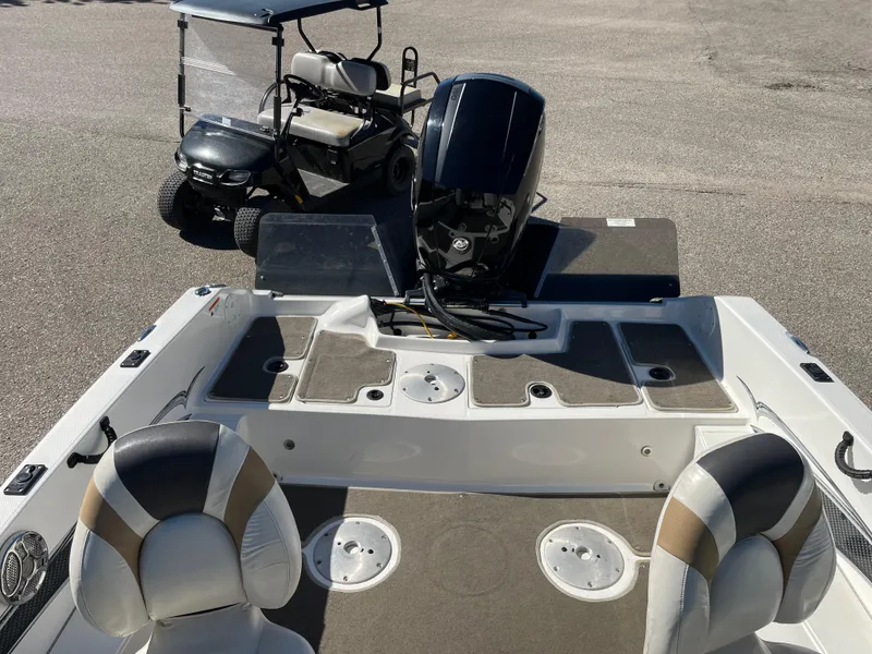 Slide: The Image of 2012 Larson FX 1750 DC boat interior with motor and golf cart in background. - 7