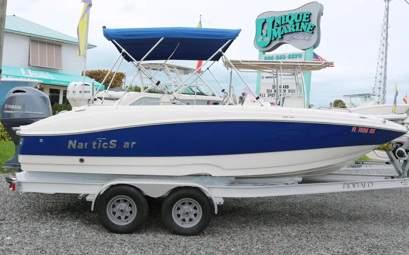 Slide: The Image of 2018 NauticStar 203 SC boat on trailer at Unique Marine dealership. - 1