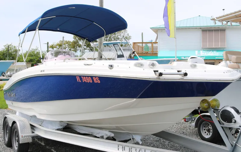 Slide: The Image of 2018 NauticStar 203 SC boat on trailer with blue canopy and white hull. - 2