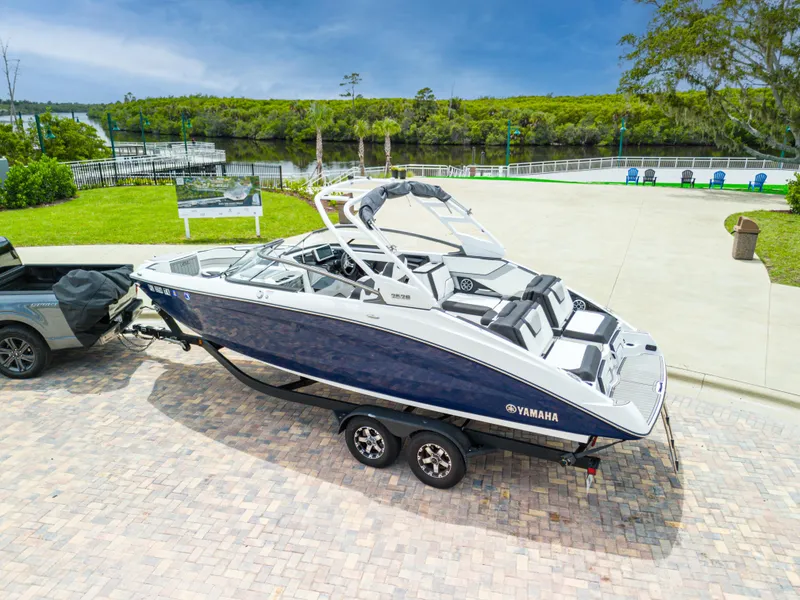 Slide: The Image of 2021 Yamaha Boats 252S on trailer, parked near scenic waterfront. - 2