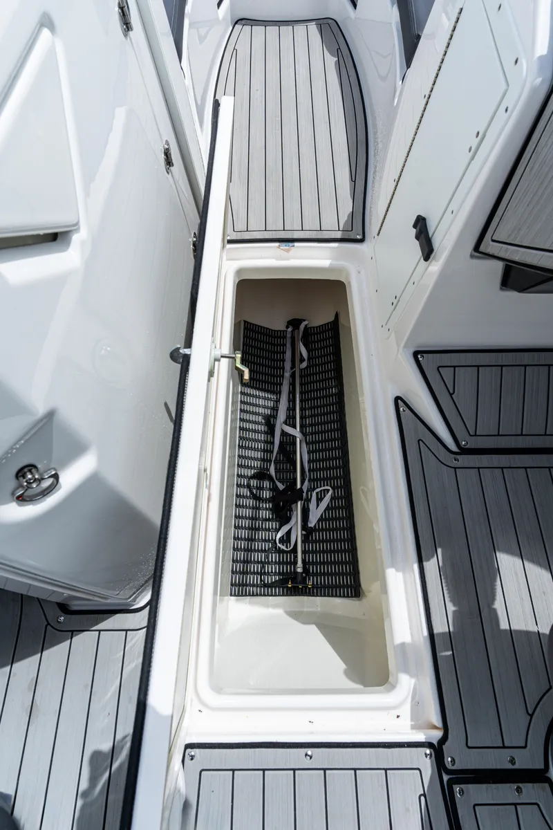 Slide: The Image of 2021 Yamaha Boats 252S storage compartment with gray decking and white interior. - 28