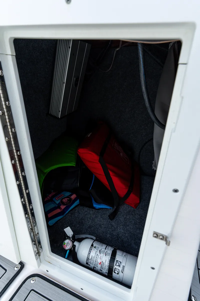 Slide: The Image of Storage compartment in 2021 Yamaha Boats 252S with life jackets and fire extinguisher. - 35