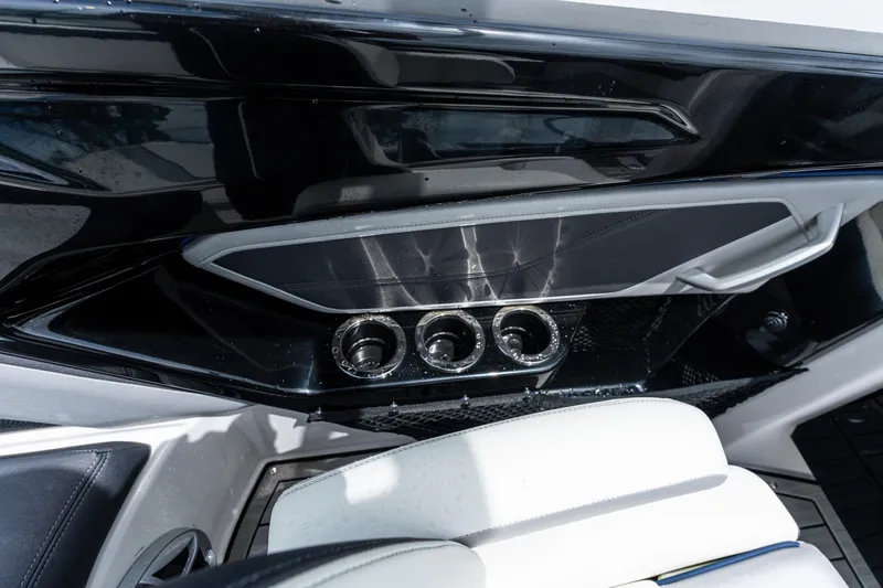 Slide: The Image of Interior of 2021 Yamaha Boats 252S, featuring sleek black paneling and cup holders. - 36