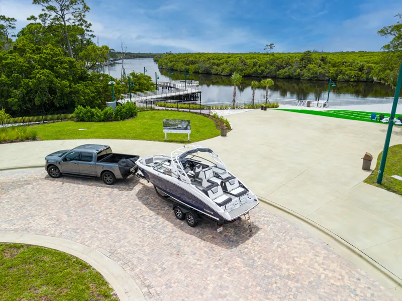 Slide: The Image of Truck towing 2021 Yamaha Boats 252S near a scenic river and lush greenery. - 5