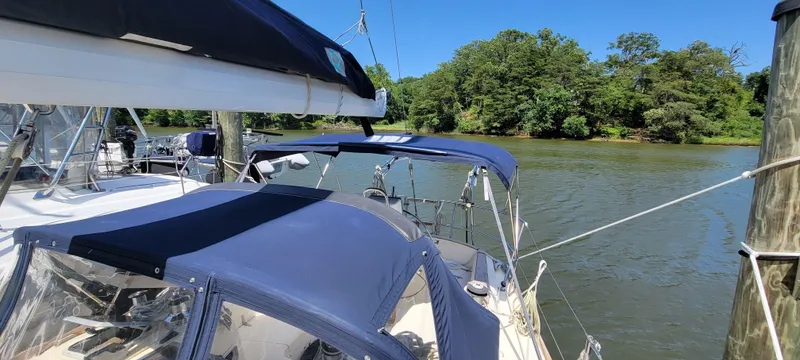Slide: The Image of 1988 Sabre 38 MkII sailboat docked on a sunny day with lush green trees in the background. - 12