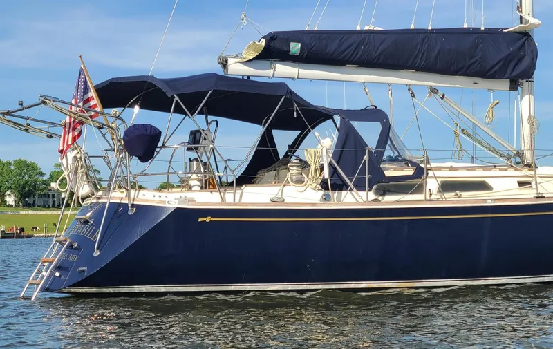 Slide: The Image of 1988 Sabre 38 MkII sailboat with blue canvas covers on the water. - 2