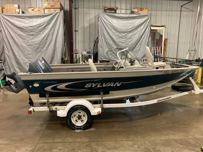 Slide: The Image of 2002 Sylvan 1600 Expedition DC boat on trailer in indoor storage. - 1