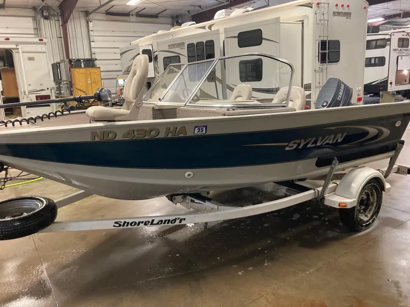 Slide: The Image of 2002 Sylvan 1600 Expedition DC boat on ShoreLand'r trailer in indoor storage. - 2