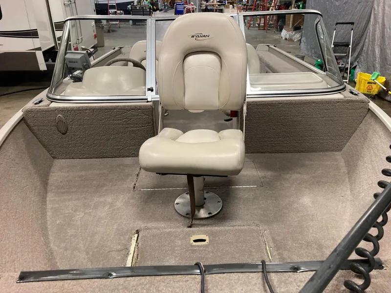 Slide: The Image of 2002 Sylvan 1600 Expedition DC boat interior with beige seating and carpet. - 4