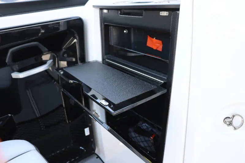 Slide: The Image of 2024 Yamaha Boats AR250 interior storage compartment with open shelf. - 10