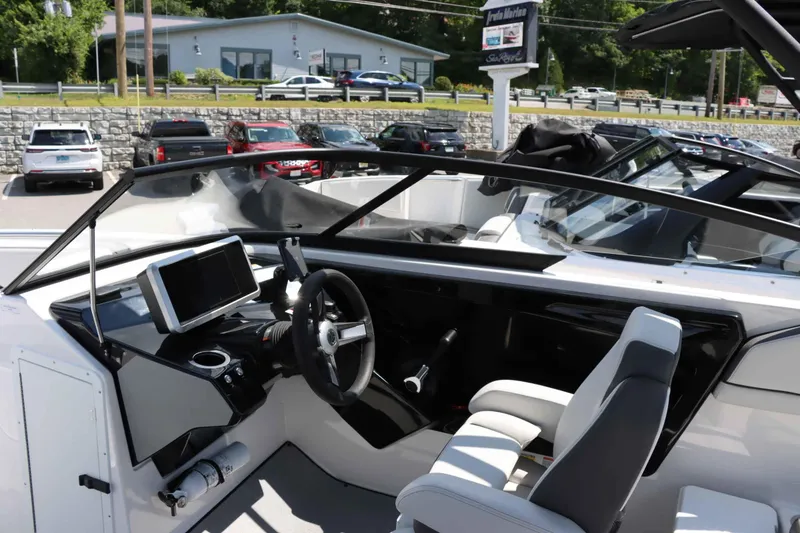 Slide: The Image of 2024 Yamaha Boats AR250 dashboard and steering wheel, parked at a marina. - 13