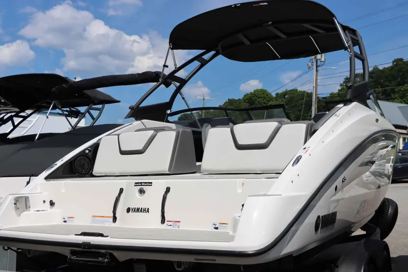 Slide: The Image of 2024 Yamaha Boats AR250, rear view, white exterior, docked under blue sky. - 3