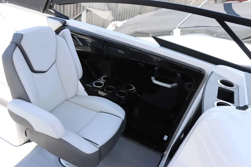 Slide: The Image of 2024 Yamaha Boats AR250 interior with white captain's chair and cup holders. - 7