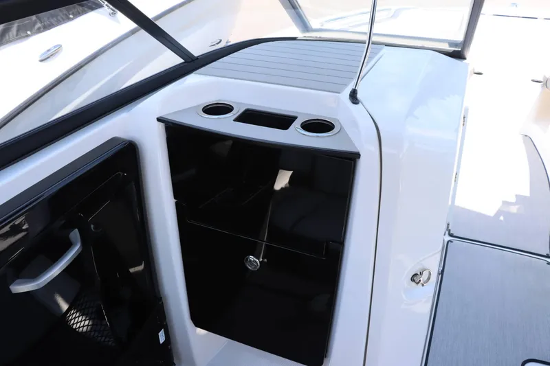Slide: The Image of Interior of 2024 Yamaha Boats AR250, featuring storage compartment and cup holders. - 9