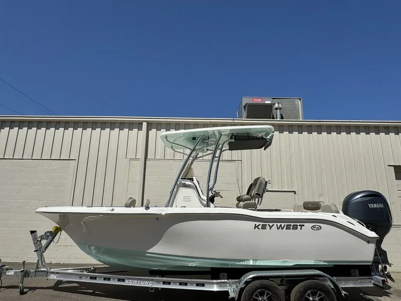 Slide: The Image of 2024 Key West 219 FS boat on trailer, side view against a building. - 0