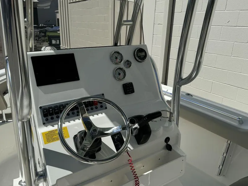 Slide: The Image of 2024 Key West 219 FS boat console with steering wheel, gauges, and controls. - 4