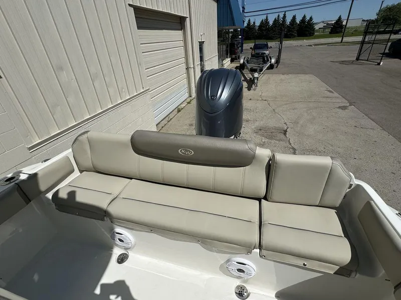 Slide: The Image of 2024 Key West 219 FS boat with cushioned seating and outboard motor. - 7