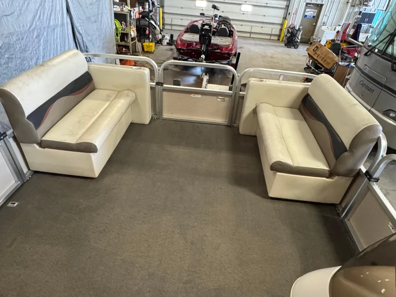 Slide: The Image of 2010 Crestliner Batata Bay 2185 interior with beige seating in a garage setting. - 15