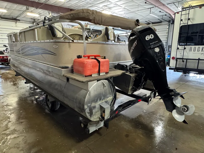 Slide: The Image of 2010 Crestliner Batata Bay 2185 pontoon boat with Mercury 60 outboard motor in a garage. - 4