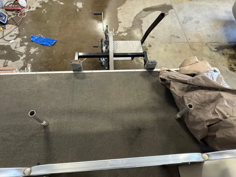 Slide: The Image of 2010 Crestliner Batata Bay 2185 boat interior with carpeted deck and metal fixtures. - 8