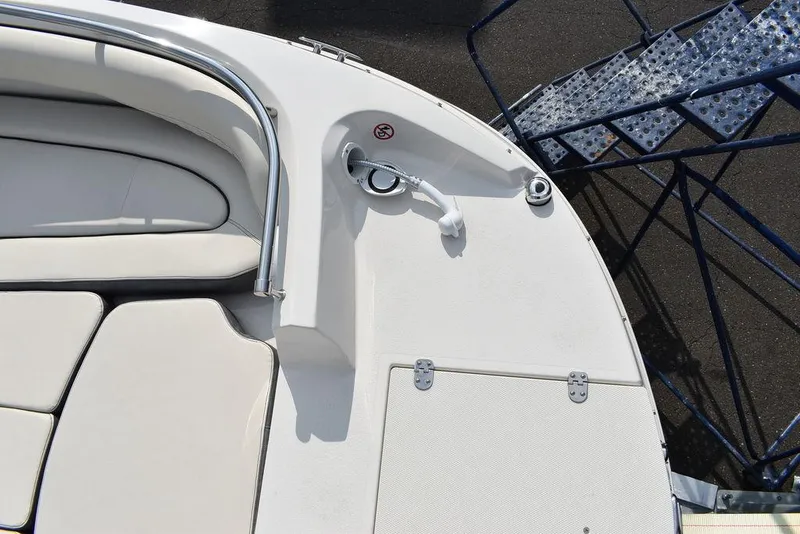 Slide: The Image of 2024 Stingray 201DC boat deck with white seating and stainless steel railing. - 16