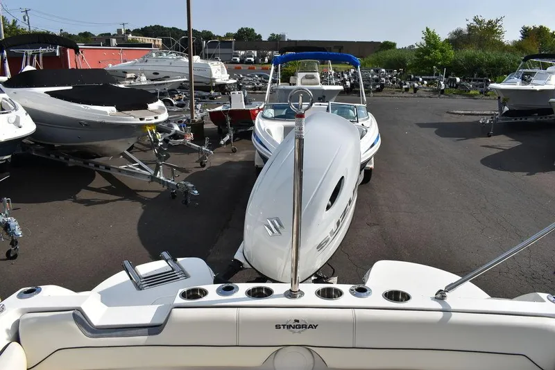 Slide: The Image of 2024 Stingray 201DC boat in a marina with other boats. - 18