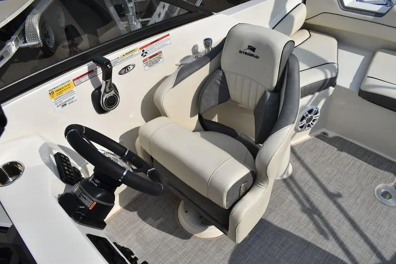 Slide: The Image of 2024 Stingray 201DC boat interior with captain's chair and steering wheel. - 29