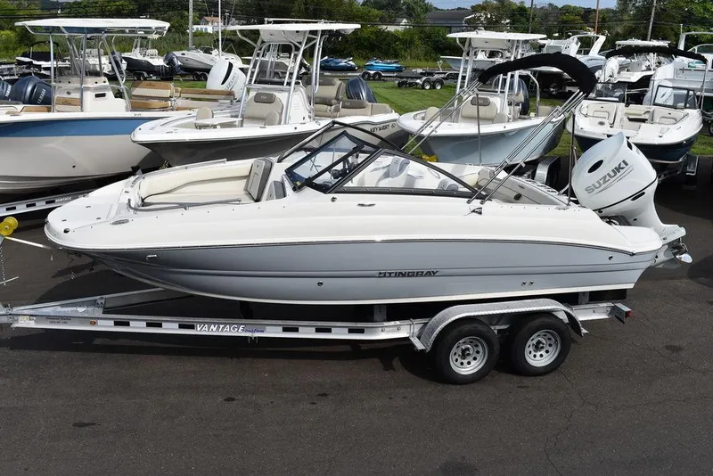 Slide: The Image of 2024 Stingray 201DC boat on trailer, surrounded by other boats in a marina. - 3