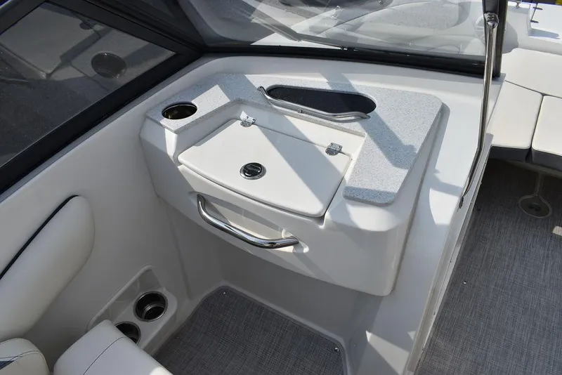 Slide: The Image of 2024 Stingray 201DC boat interior with storage compartment and cup holders. - 31