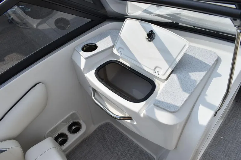 Slide: The Image of 2024 Stingray 201DC boat interior with storage compartment and cup holders. - 32