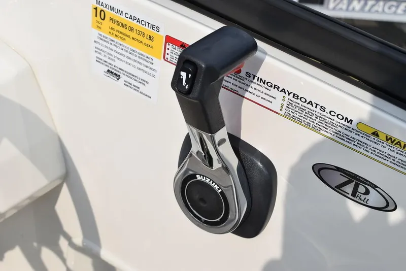 Slide: The Image of 2024 Stingray 201DC boat throttle control with capacity label and Suzuki branding. - 33