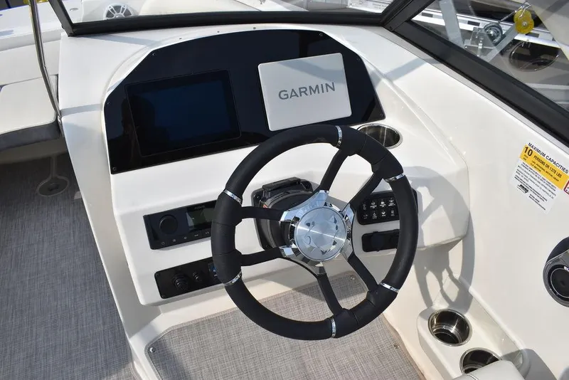 Slide: The Image of 2024 Stingray 201DC boat dashboard with Garmin navigation system and steering wheel. - 36