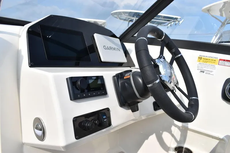 Slide: The Image of 2024 Stingray 201DC boat dashboard with Garmin navigation and steering wheel. - 37