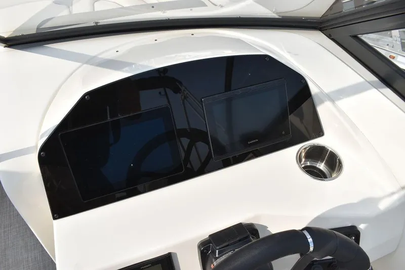 Slide: The Image of 2024 Stingray 201DC boat dashboard with dual screens and cup holder. - 38