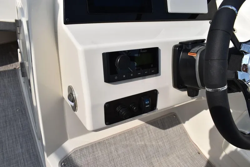 Slide: The Image of 2024 Stingray 201DC boat dashboard with steering wheel and control panel. - 40
