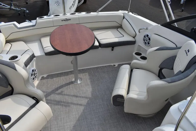 Slide: The Image of 2024 Stingray 201DC boat interior with plush seating and round table. - 46