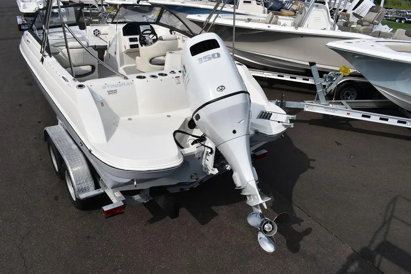 Slide: The Image of 2024 Stingray 201DC boat on trailer, featuring powerful outboard motor. - 5