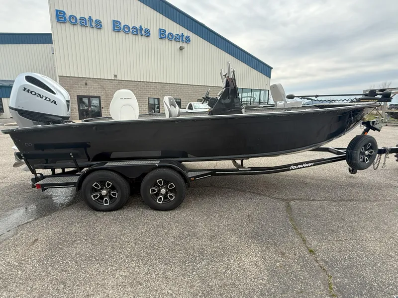 Slide: The Image of 2023 Polar Kraft Outlander 2010 CC boat with Honda engine, parked outside a dealership. - 0