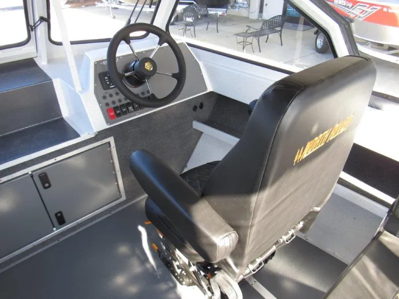 Slide: The Image of Interior of 2024 North River 23 SEAHAWK RTF boat, featuring steering wheel and captain's chair. - 12