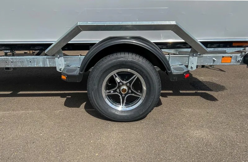 Slide: The Image of 2024 Hewescraft 200 Sportsman trailer wheel and tire on asphalt. - 17