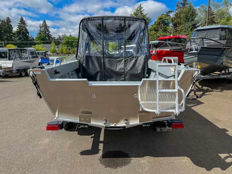Slide: The Image of 2024 Hewescraft 200 Sportsman boat, rear view, parked outdoors with other boats. - 4