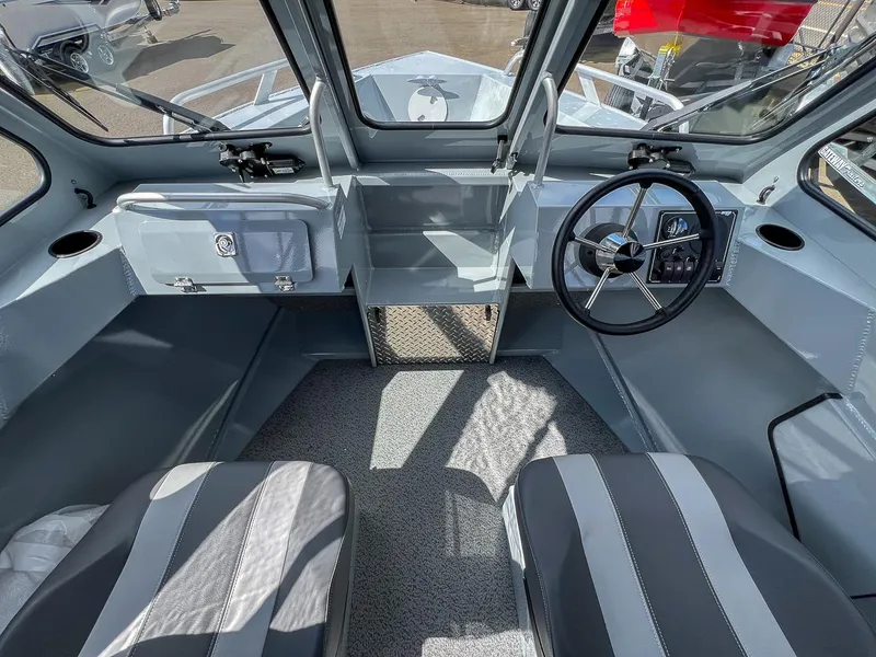 Slide: The Image of Interior of 2024 Hewescraft 200 Sportsman boat, featuring steering wheel and seating. - 8