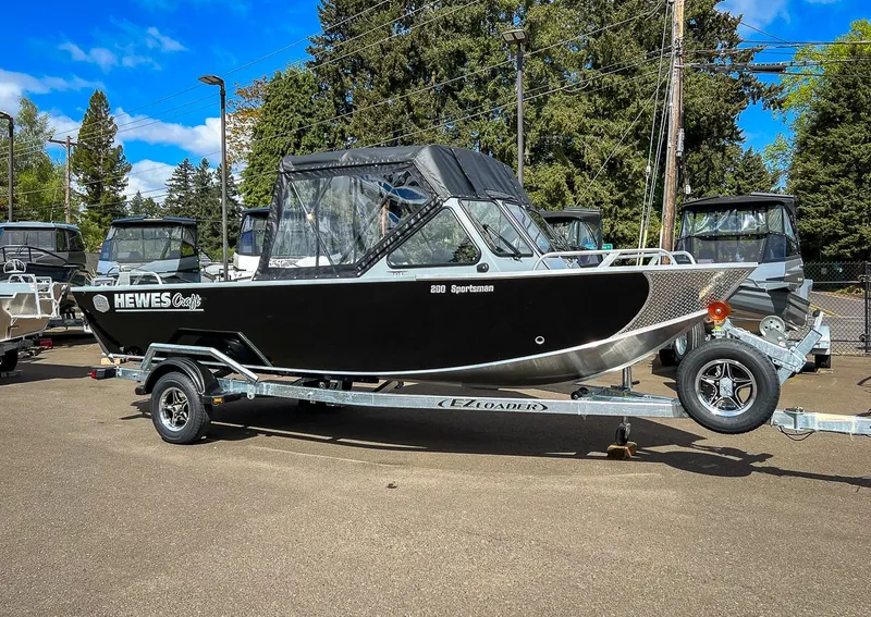 Slide: The Image of 2024 Hewescraft 200 Sportsman boat on trailer, black exterior, parked outdoors. - 1