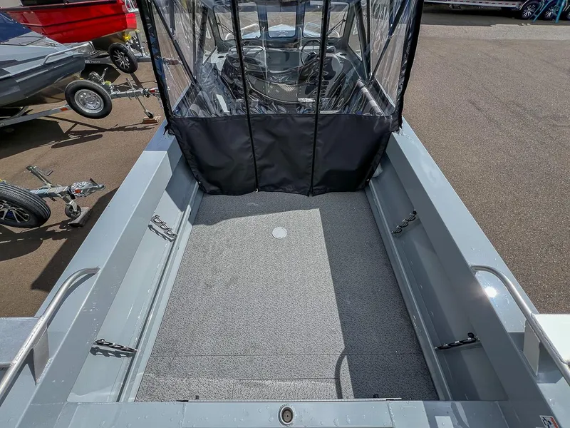Slide: The Image of 2024 Hewescraft 200 Sportsman boat interior with covered cockpit and trailer in background. - 15