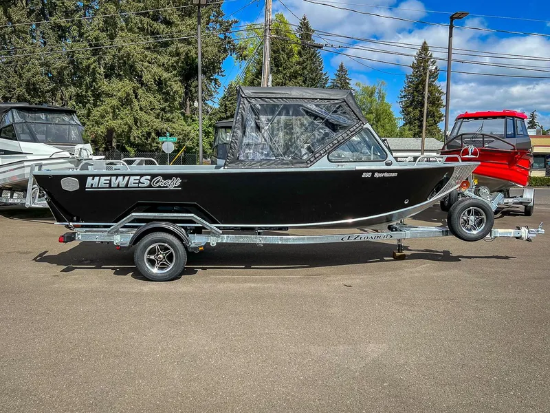 Slide: The Image of 2024 Hewescraft 200 Sportsman boat on trailer, black exterior, parked outdoors. - 2