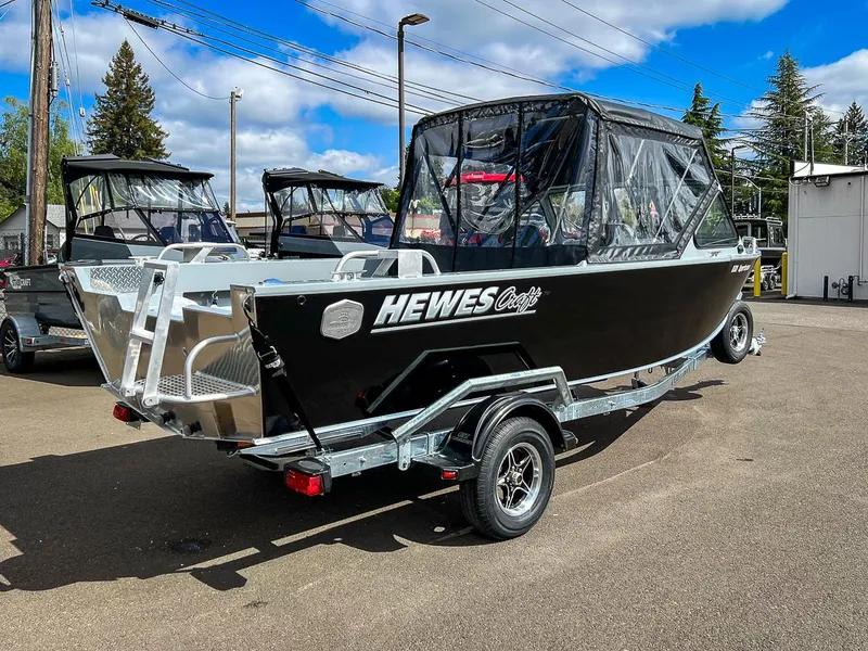 Slide: The Image of 2024 Hewescraft 200 Sportsman boat on a trailer, parked outdoors under a blue sky. - 3