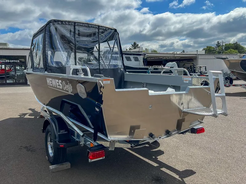 Slide: The Image of 2024 Hewescraft 200 Sportsman boat with canopy, parked on a trailer in a dealership lot. - 5